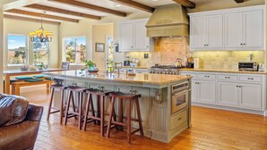 A spacious kitchen with a large island, white cabinetry, and a view of the outdoors. - 40 Acres + Home Office + Views | Paso Robles | Skyeranch-30 Day Rental (San Miguel)