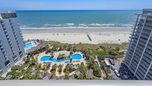 Ein Resort mit Strandlage, Poolbereich und Hochhäusern.