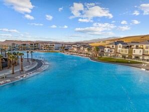 Ein Resort mit großem Schwimmbad, mehreren Gebäuden und Palmen.