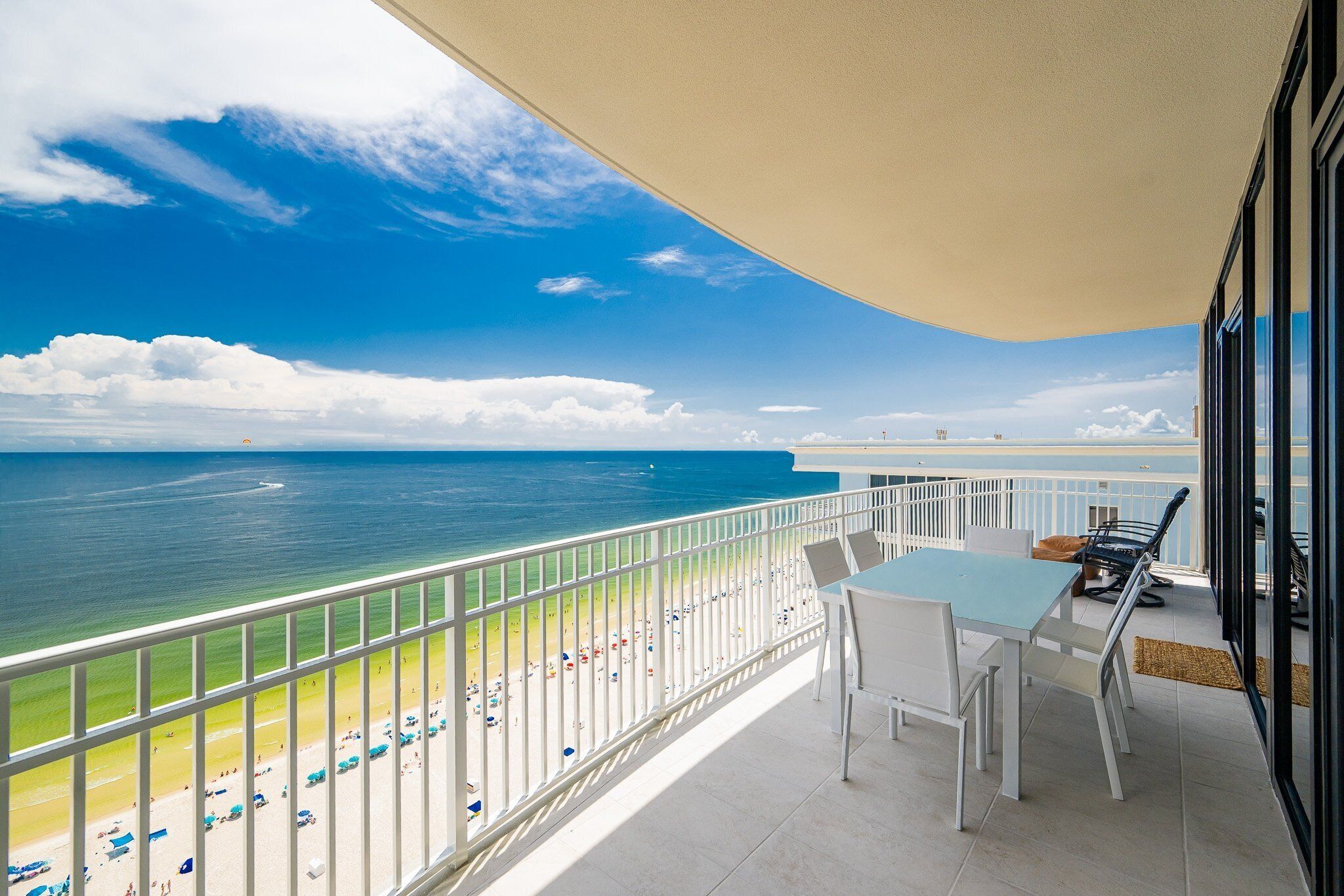 A balcony with a view of the beach and ocean.