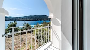 A balcony with a view of a lake and hills.