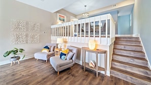 A modern living room with two grey sofas, a wooden coffee table, and a staircase leading to a second floor. - Siesta Beach Retreat 2 Bedroom Townhouse (Siesta Key)