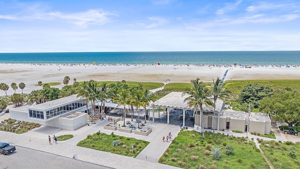 A beachside hotel with a pool area, palm trees, and a view of the ocean. - Siesta Beach Retreat 2 Bedroom Townhouse (Siesta Key)
