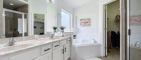 Un baño moderno con un espejo grande, tocador y bañera.