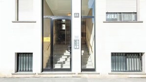 A building entrance with a glass door, a staircase leading inside, and a number 41 sign above the door.