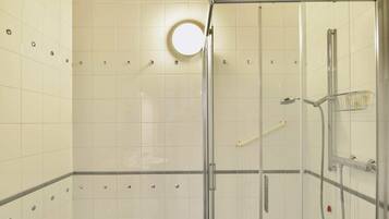 Un bagno con box doccia in vetro, lavabo e WC.