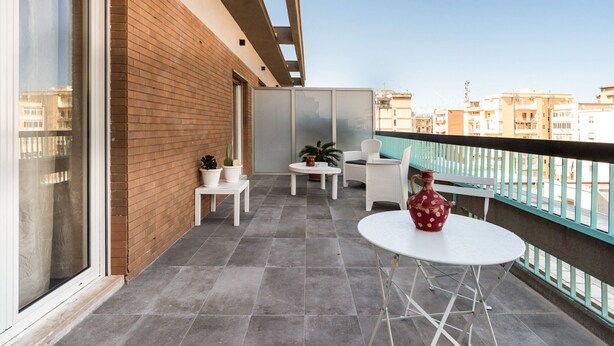 A balcony with a white table and chairs, a red vase, and potted plants. - Gil s Penthouse by Wonderful Italy (Bari)