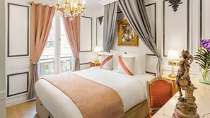 Ein Hotelzimmer mit einem großen Bett, einer Kandelaber, einer Statue und Blick ins Freie.