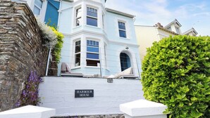 Una casa azul claro con un letrero que dice "Harbour House".
