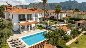 A residential area with houses, a swimming pool, and mountains in the background. - Villa Pala Dalyan (Unknown)