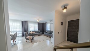 A spacious living area with a modern sofa set, a dining table, and a staircase leading to another level. - Villa Pala Dalyan (Unknown)