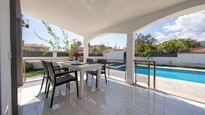 A covered patio with a pool, outdoor furniture, and a view of neighboring houses. - Villa Pala Dalyan (Unknown)