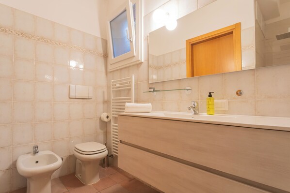 A bathroom with a bidet, toilet, sink, mirror, and towel rack. - The Secret Lake View by Rent all Como (Pognana Lario)