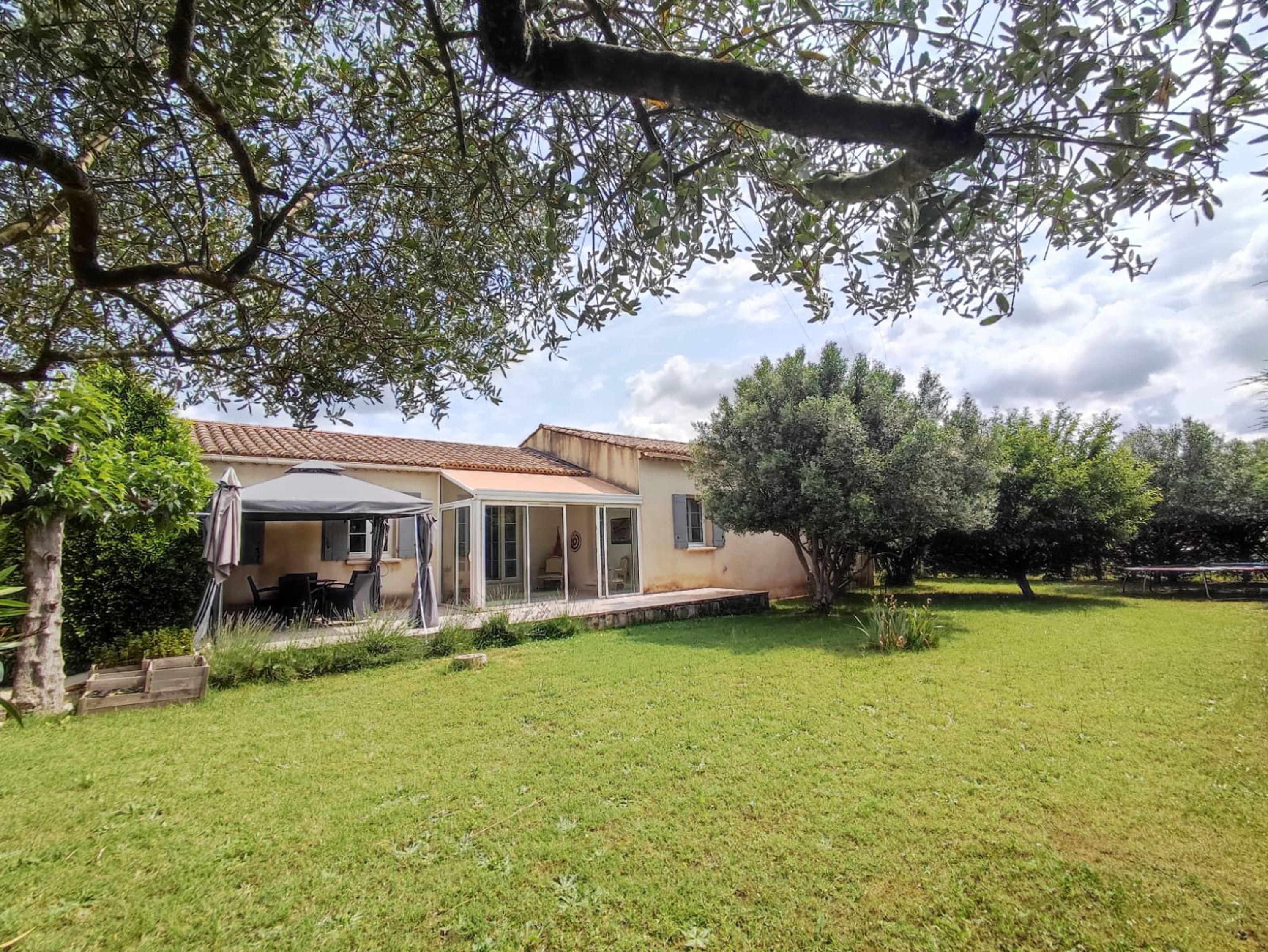 Una casa con patio, zona relax coperta e prato.