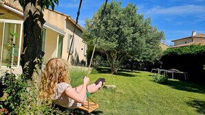 A child on a swing in a well-maintained garden with a house in the background. - Villa - Pool - 3 Bedrooms - Garden (Saint-Quentin-la-Poterie)
