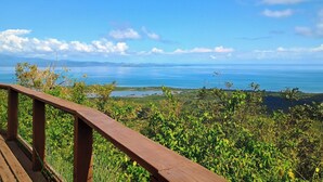 A wooden deck overlooking a coastal landscape with a view of the sea and distant mountains. - Room w/ba AC Wi-Fi in Esperanza Apt. 1 (Vieques)