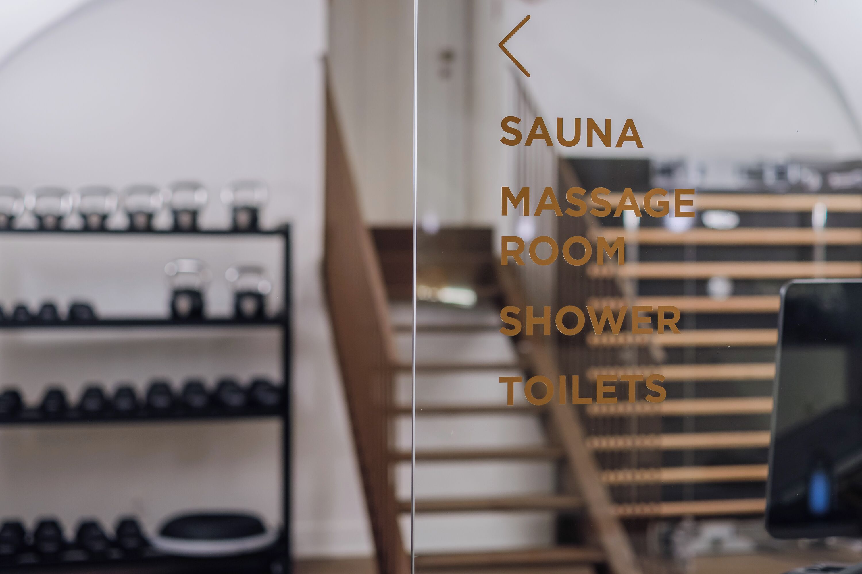 Un panel de vidrio con indicaciones de sauna, sala de masajes, ducha y sanitarios.