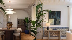 A dining area with a round wooden table, chairs, and potted plants.