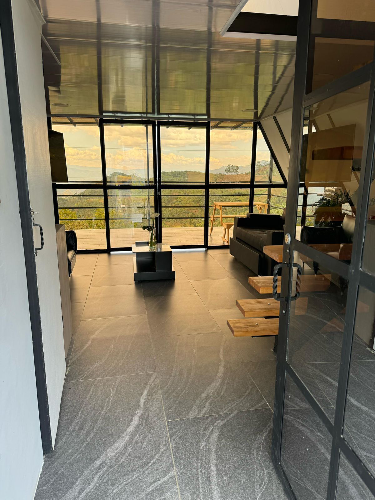 Ein modernes Interieur mit einer großen Glastür, die auf einen Balkon mit schöner Aussicht führt.
