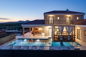 A modern house with a swimming pool, outdoor seating, and a view of the mountains. - Villa Alba ZadarVillas (Vrana)