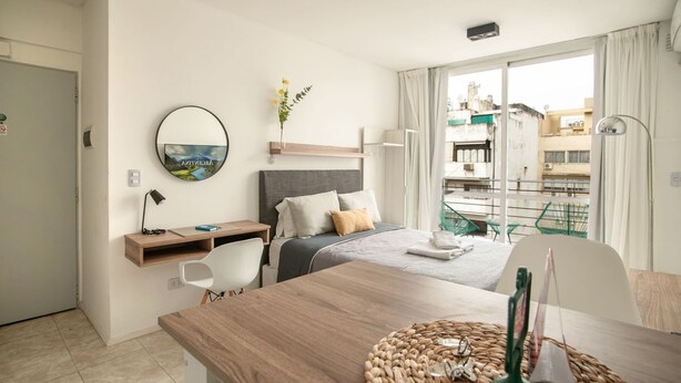 Une chambre d’hôtel avec un lit, un bureau, une chaise et une vue sur la ville.