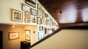 A hallway with a wooden ceiling and walls adorned with framed artwork.