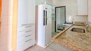 A kitchen with a white refrigerator, a stove, and a sink.