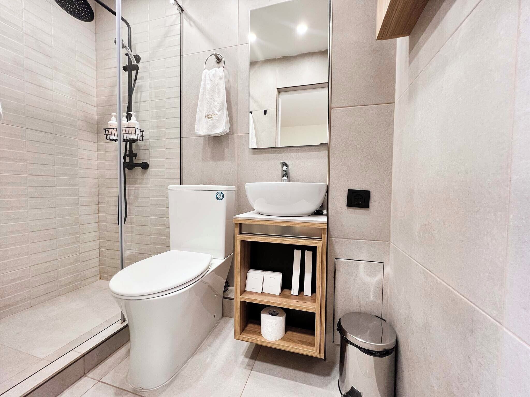 Un baño moderno con inodoro, lavamanos y ducha.