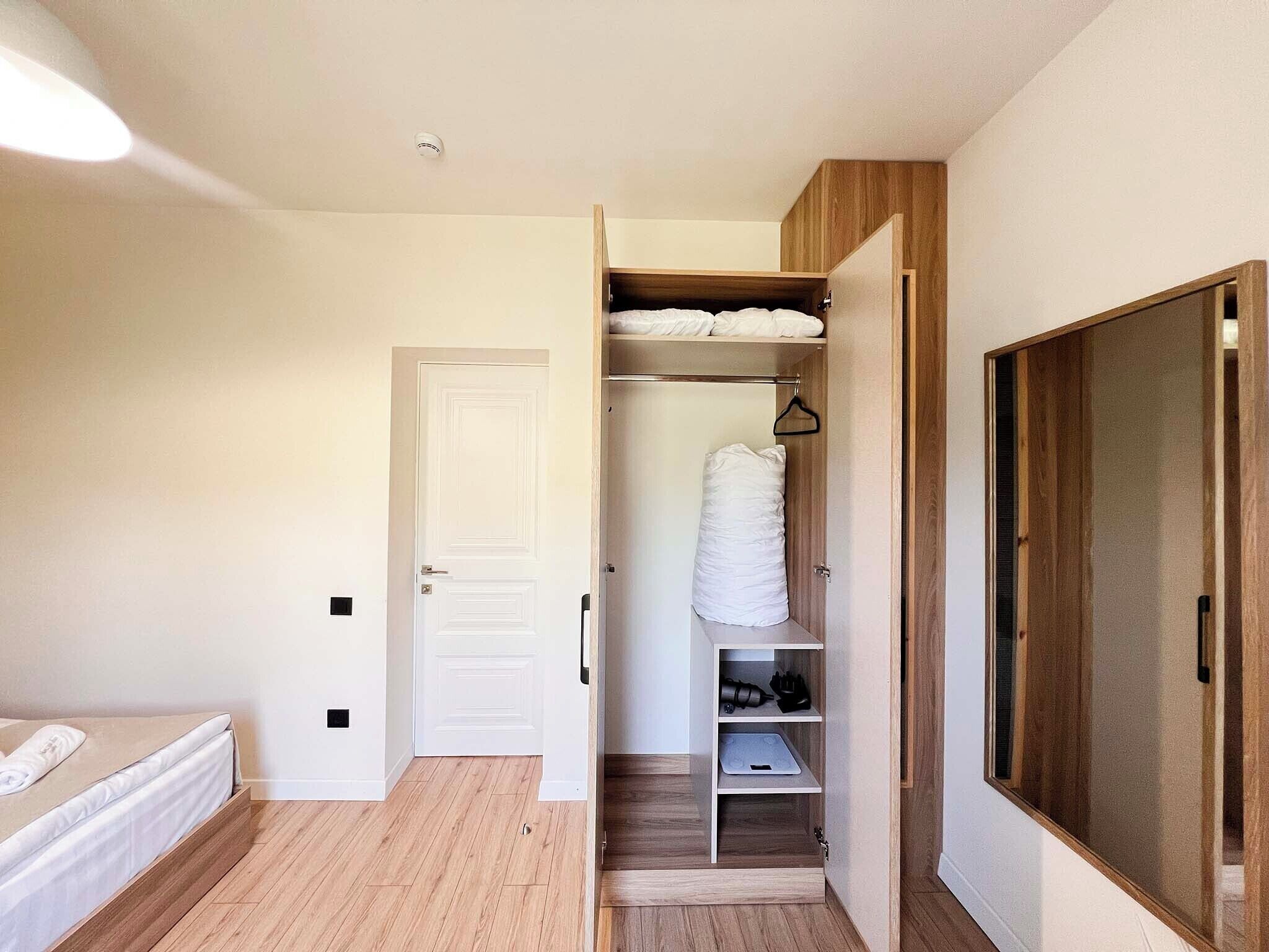 Un dormitorio con una cama, un armario y una alacena con estantes.