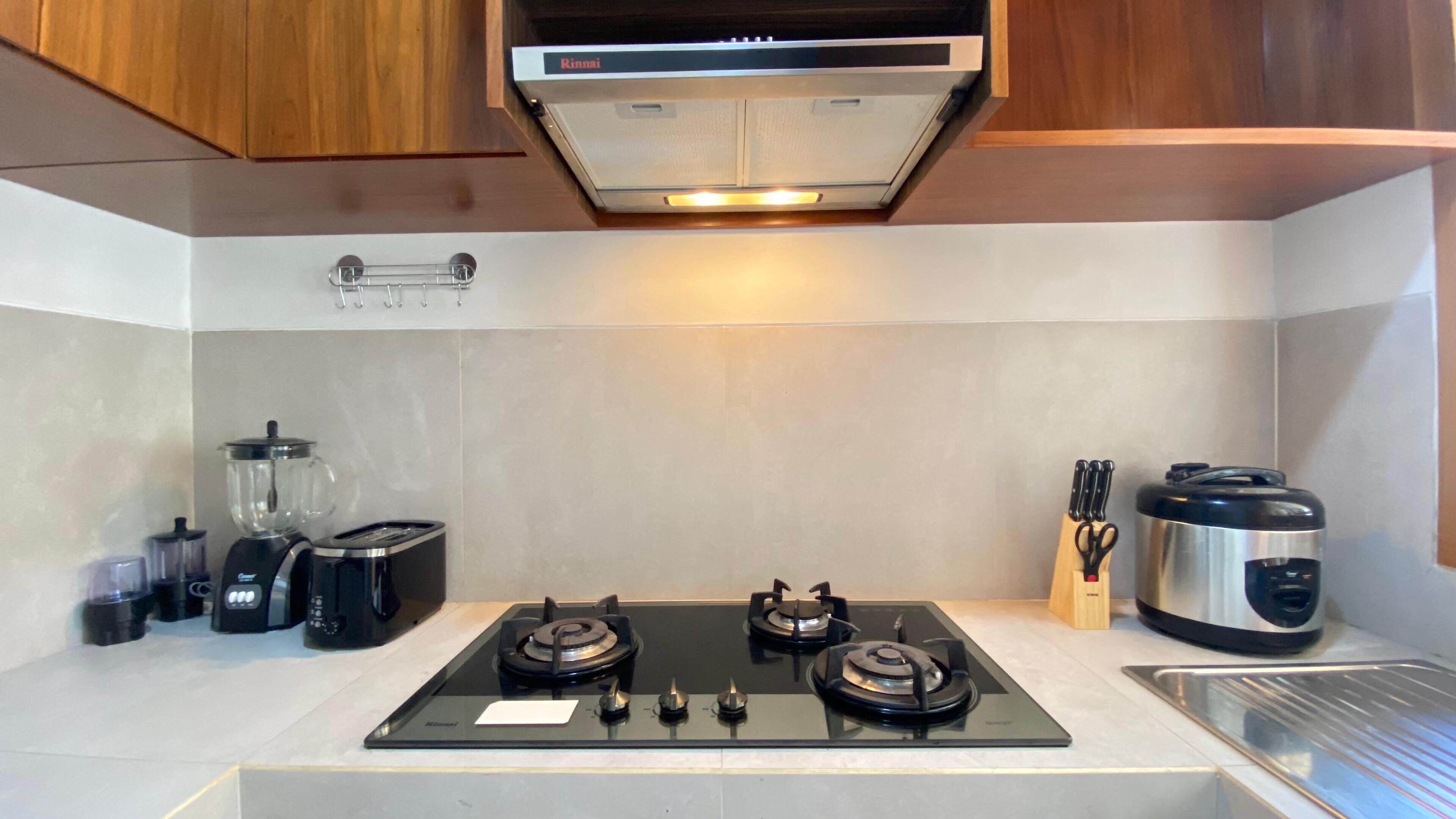 Eine moderne Küche mit Gasherd, Kaffeemaschine, Toaster und Mixer.