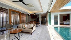 Amplia sala de estar con piscina, comedor y cocina.
