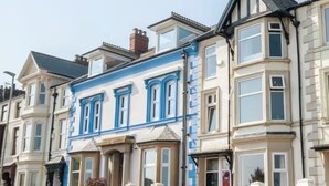 A row of townhouses with bay windows, a garage, and a driveway with parked cars. - Seaview Retreat - Breathtaking coastal views, 2 bedroom apartment (South Shields)