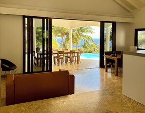 Un intérieur moderne comprenant un espace repas, une piscine et une vue sur l’océan.