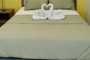 A bed with a green bedspread and two white towels arranged in the shape of swans. - Ocean View Villa in Coral Estate-4Bedrooms-Pool-family-friendly-Walk to Beach. (Coral Estate, Curaçao)