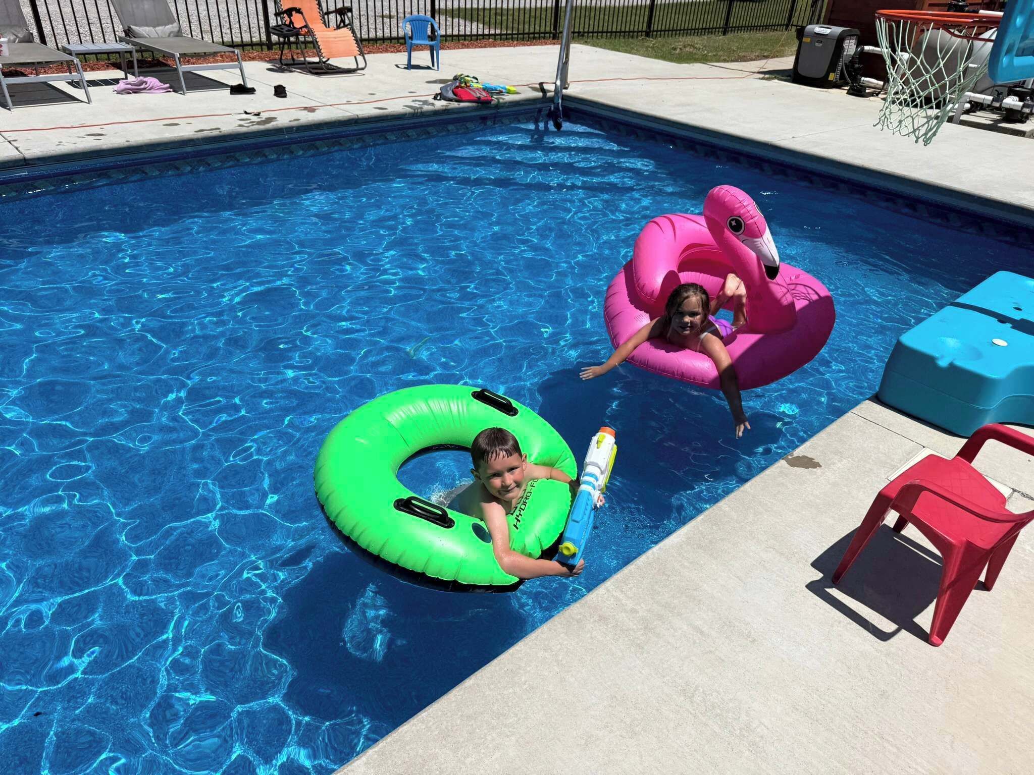 Ein Swimmingpool mit Schwimmreifen und Liegestühlen.