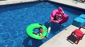 Ein Swimmingpool mit Schwimmreifen und Liegestühlen.