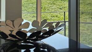 A room with large windows overlooking a green landscape and a bridge. - Bridge River Apartment @ Parque das Nações (Lisboa)