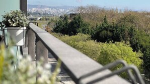 A balcony with a view of a cityscape and greenery. - Bridge River Apartment @ Parque das Nações (Lisboa)