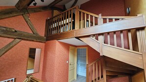 Un escalier en bois, doté d’une rampe également en bois, menant à un deuxième étage.