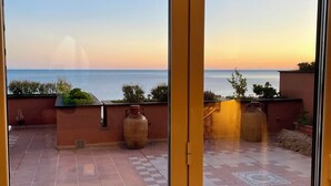 A terrace with a view of the sea, featuring tiled flooring and large ceramic pots. - Welcome to your Seaside Home (Varazze)