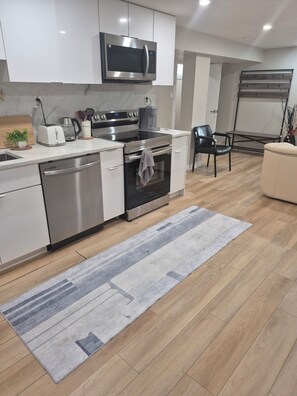A modern kitchen with stainless steel appliances, a dishwasher, and a microwave.