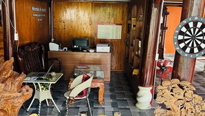 A restaurant with wooden decor, a dartboard, and a menu on the wall.