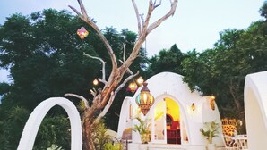 A white building with arched doorways and a central illuminated lantern. - VistaMonti Private Villas (Pemenang)