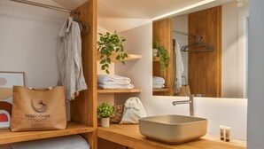 A modern bathroom with a wooden vanity, a large mirror, a sink, and a towel rack. - Marconia Boutique Residence   Dúplex Premium (Girona)