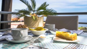 A table with a croissant, a slice of cake, a cup, and a bowl of fruit. - TPH Rooms (Taormina)
