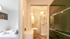 A modern hotel room with a bed, a bathroom with a shower, and a mirror. - Bright one bedroom Porta Venezia - Mirable PM (Milano)