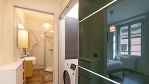 A modern bathroom with a shower, a washing machine, and a bed in a separate room. - Bright one bedroom Porta Venezia - Mirable PM (Milano)