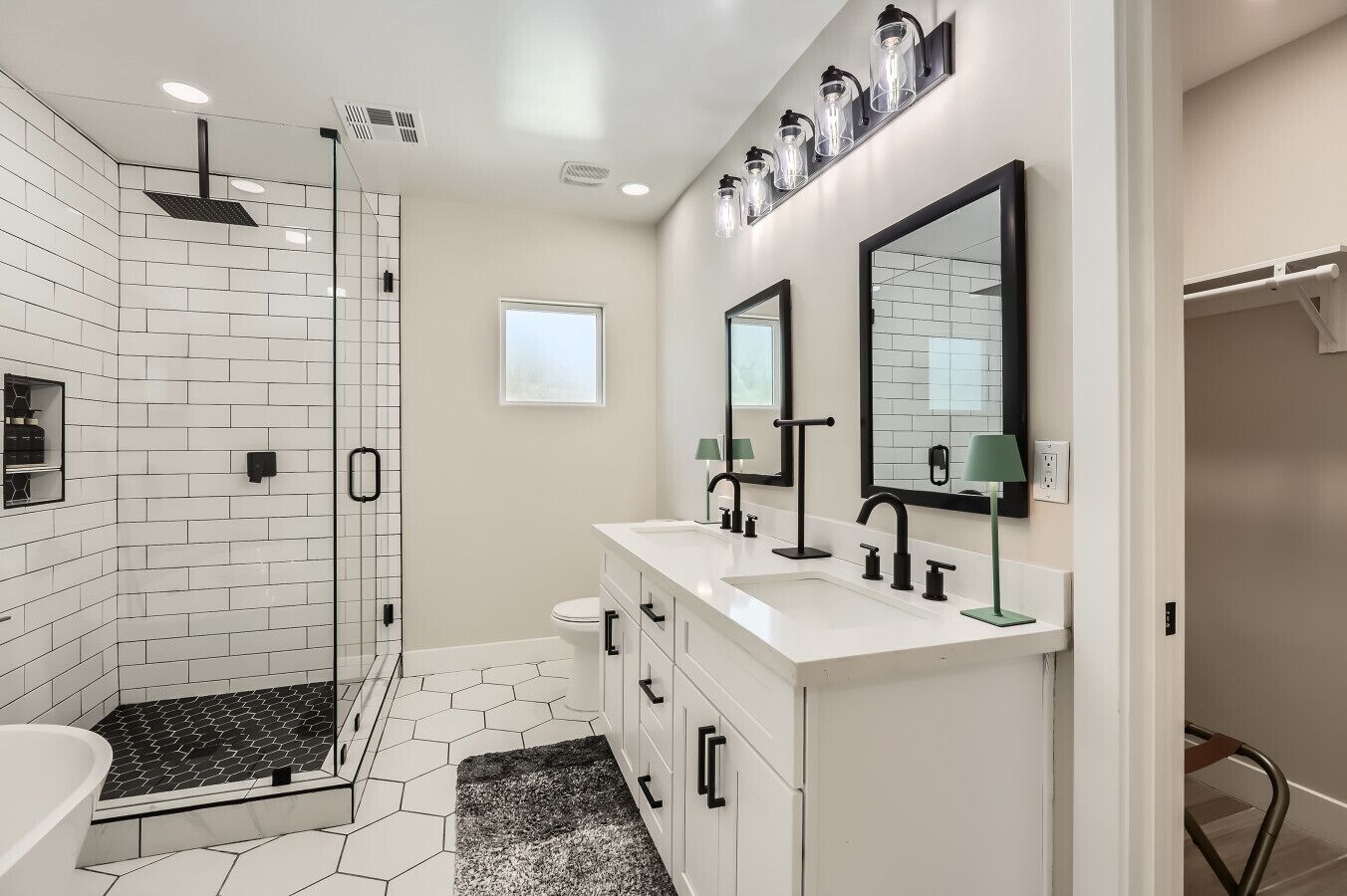 Une salle de bain moderne équipée d’une douche, de deux lavabos et de toilettes.