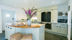 A modern kitchen with a central island, built-in appliances, and a large window.