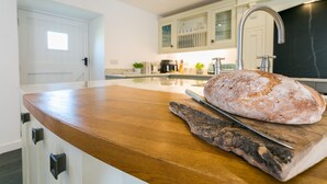 Une cuisine avec un plan de travail en bois, une miche de pain et une planche à découper.